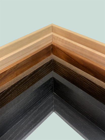 Day and Night Woodworking close-up of wooden float picture frames with different finishes on a light background